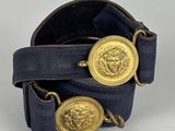 a close up of a belt with two gold buttons on it