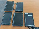 quatre téléphones portables posés sur une table à côté d'une paire de ciseaux