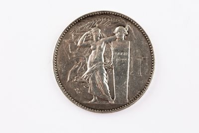 une vieille pièce d'argent sur laquelle figure une statue, sur un fond blanc