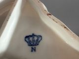 a white and blue vase with a crown on it