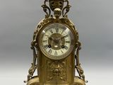 a gold clock sitting on top of a table