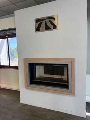 a fireplace in the middle of a room with a painting on the wall