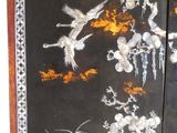 two black and gold painted panels with birds and flowers on them