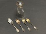 five spoons and a salt shaker on a table