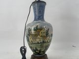 a blue and white vase on a wooden stand with a power cord
