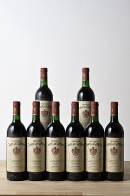 six bottles of red wine lined up on a wooden table