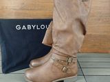 the boots are on the floor next to a black bag