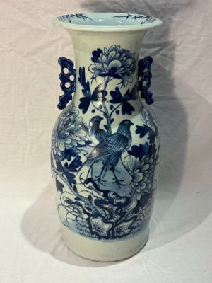 un vase bleu et blanc avec un oiseau dessus