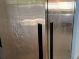 a stainless steel refrigerator sitting on wheels in a room