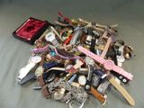 un tas de montres diverses et d'autres montres posées sur un lit