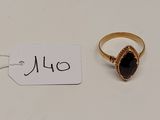 une bague en or sertie d'une pierre noire, avec une étiquette de prix