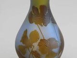 un vase bleu orné de fleurs jaunes, posé sur un fond blanc