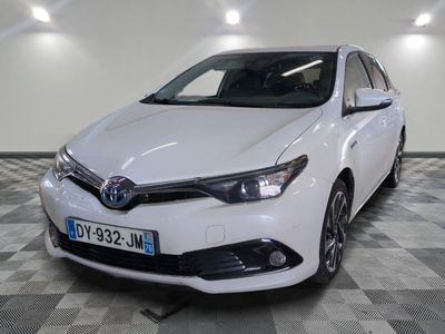 La Toyota Corolla blanche est garée dans une pièce dont le sol est en damier.