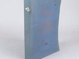 an old book sitting on top of a table next to a white wall