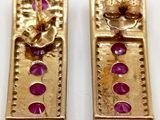 pair of gold tone earrings with pink stones on them on a white surface