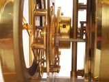 a gold clock that is on display in a glass case