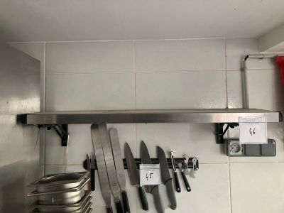 une photo d'une cuisine où l'on voit plusieurs couteaux accrochés au mur