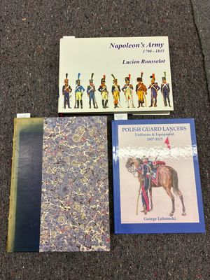 trois livres sont posés par terre, les uns à côté des autres