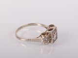a close up of a diamond ring on a white surface