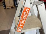 a ladder that has a sign on it in a store