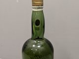 a green bottle that is sitting on a white table