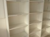 a white bookcase in the corner of a room