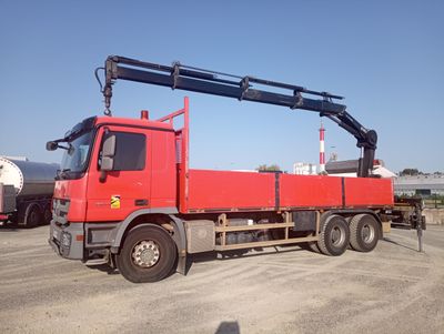 un gros camion rouge équipé d'une grue à l'arrière