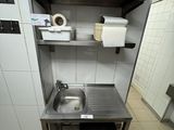 a small kitchen with a sink and a trash can