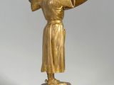 gold statue of a man holding a sword on a marble base