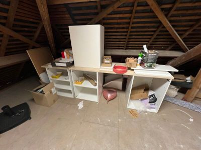 a room with a refrigerator, shelves, and other items in it