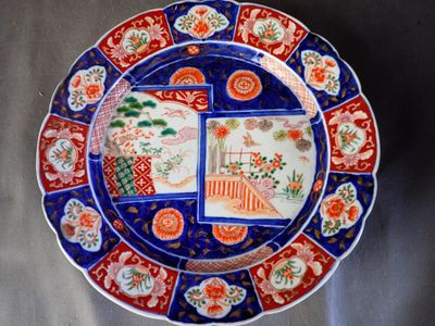 une assiette bleue ornée de motifs rouges et blancs
