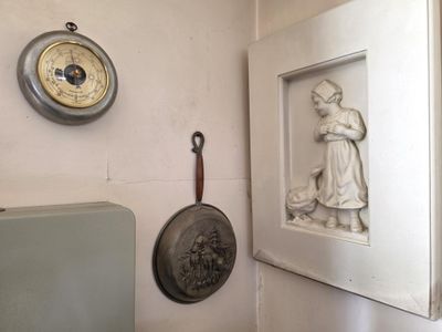 une photo d'un mur sur lequel sont accrochés une horloge et des casseroles
