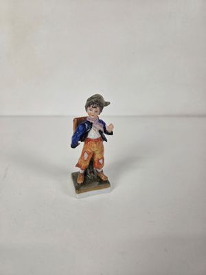 figurine of a boy with a backpack on a white background