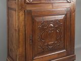 une vieille armoire en bois dont les portes et les tiroirs sont sculptés