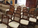 de nombreuses chaises et canapés dans une pièce où est accroché un tableau au mur