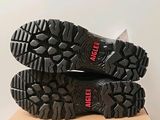 the soles of a pair of black hiking shoes on top of a cardboard box
