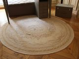 un grand tapis rond posé au sol dans une chambre à coucher