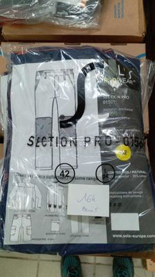 une photo d'une personne debout à côté d'un carton de vêtements