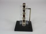 silver bracelet with garnets on display on a black stand