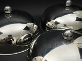 trois plats recouverts d'argent posés sur une table noire
