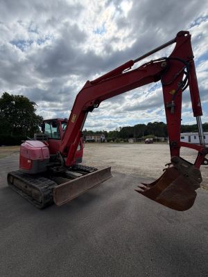 une pelleteuse rouge garée sur un parking