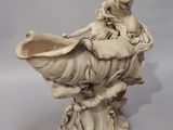 statue of a woman sitting on a shell with a bird on it