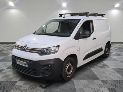 la camionnette blanche est garée dans une pièce au sol en damier