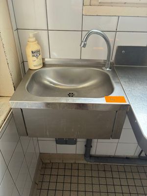 un lavabo dans un coin d'une salle de bains dotée d'une fenêtre