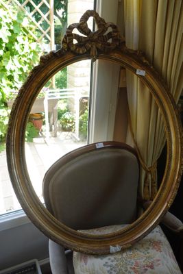 un miroir posé sur une chaise devant une fenêtre
