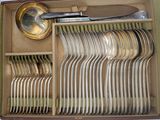a lot of silverware in a box with a spoon and spoon rest