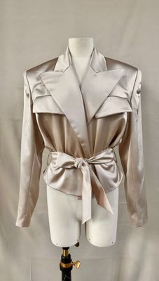 an image of a mannequin wearing a beige jacket with a bow tie