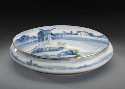 une assiette bleue et blanche sur laquelle est représenté un château