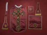 une image représentant les vêtements et les accessoires d'un prêtre sur fond rouge