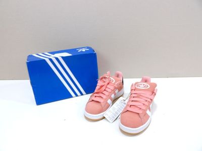 des baskets Adidas roses et blanches et une boîte bleue posée sur une table blanche
